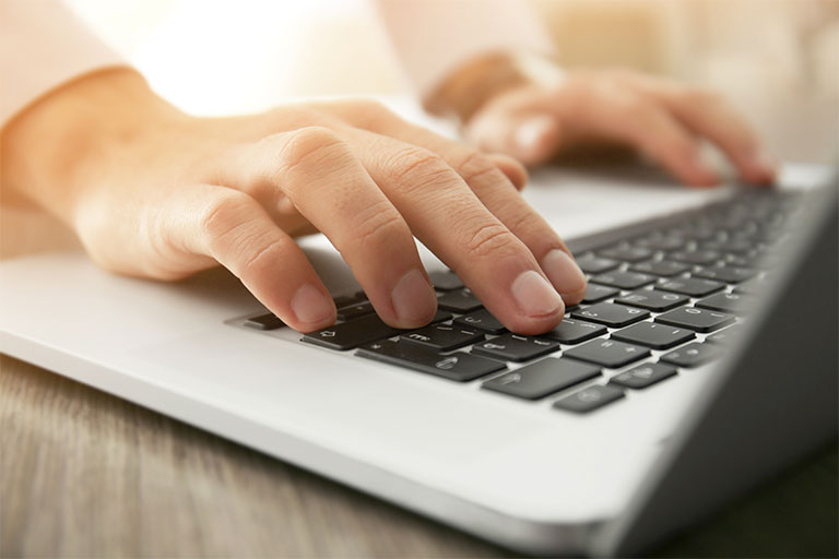 Woman using keyboard on laptop